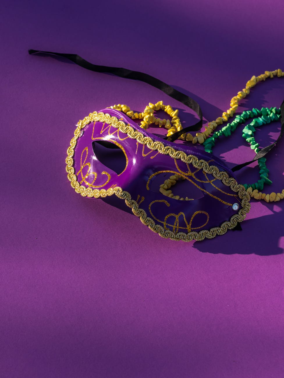 close up shot of a carnival mask on a purple surface